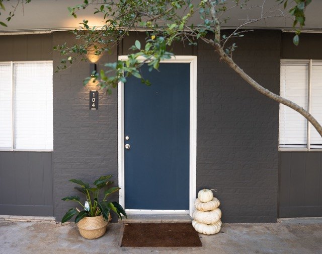 Blue front door with a modern wall sconce