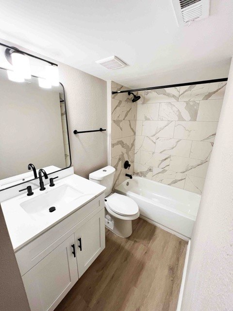 Bathroom with a new vanity, matte black fixtures, and marble-look tile